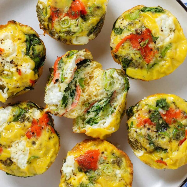 several egg muffins with salmon on a plate one cut open