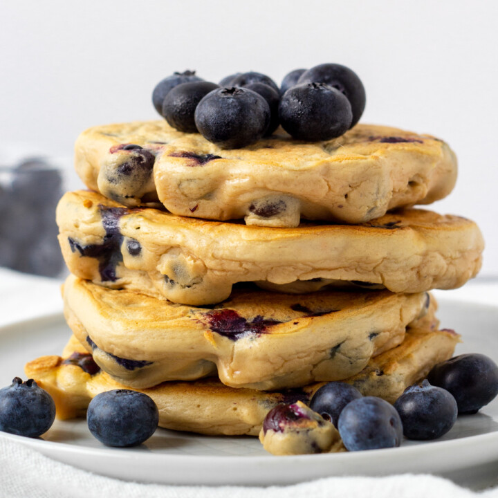 stack of gluten free blueberry protein pancakes with fresh blueberries