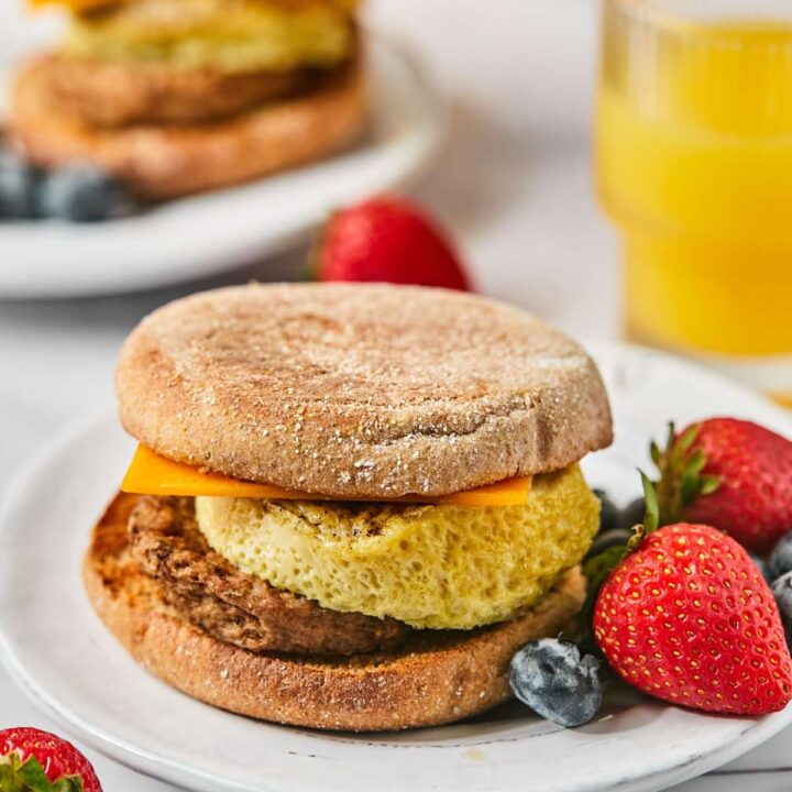 high protein breakfast sandwich on a plate with fresh berries