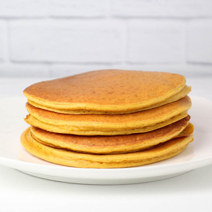 a stack of pumpkin protein pancakes on a white plate